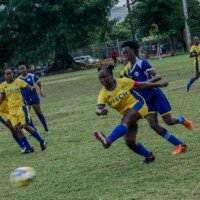 UTech and NCU players contest possession during their female football competition.